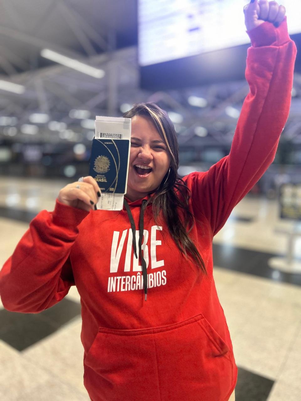 Estudante Vibe Intercâmbios no embarque com passaporte.